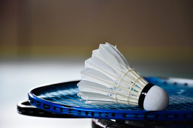 Cream white badminton shuttlecock and racket with neon light sha